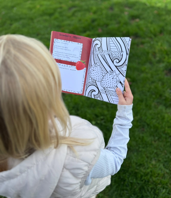 Ngā Tae o Ngā Huarākau A5 colouring book being coloured by a child